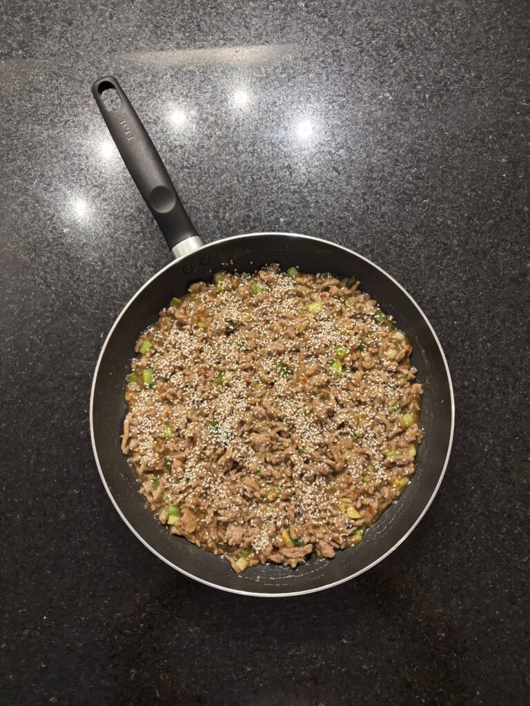 Sweet chili chicken in a skillet on a black countertop